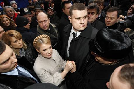 Julija Tymoenková v obklopení bodyguard se zdraví s píznivci